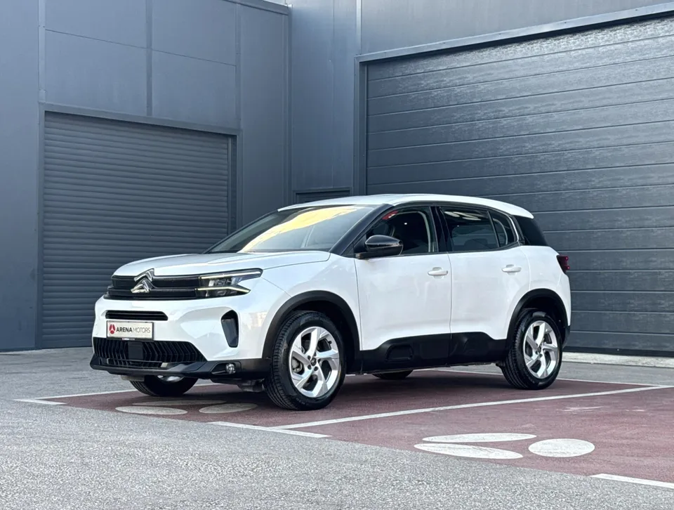 Citroen C5 Aircross, bijela boja, prednji lijevi bočni pogled ispred sivog objekta