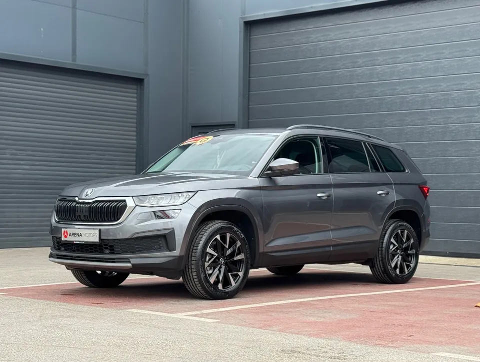 Siva Škoda Kodiaq, prednji bočni pogled s lijeve strane, ispred sivih garažnih vrata
