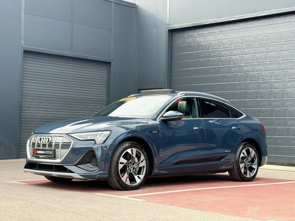 Audi e-tron Sportback u plavoj boji, pogled sprijeda sa strane ispred sive garaže
