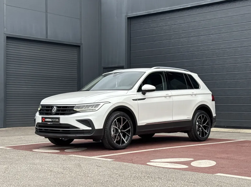 Bijeli Volkswagen Tiguan, prednji lijevi bočni pogled ispred sivih garažnih vrata