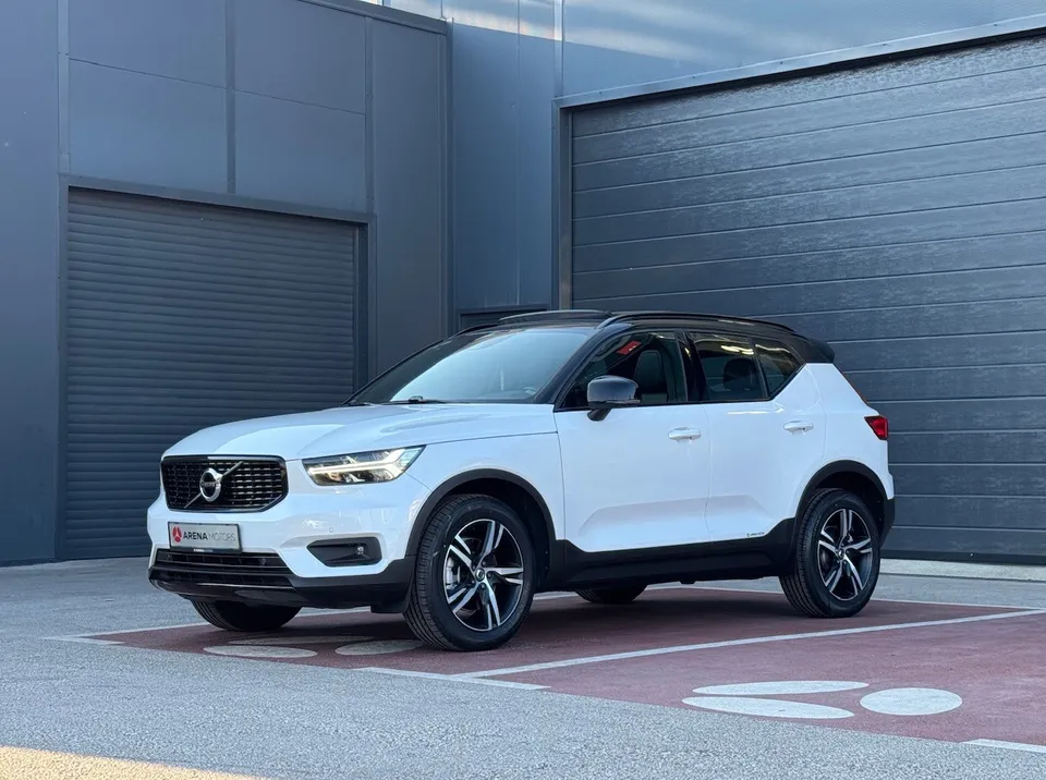Bijeli Volvo XC 40 R-Design, bočni prednji pogled s lijeve strane, ispred sive hale