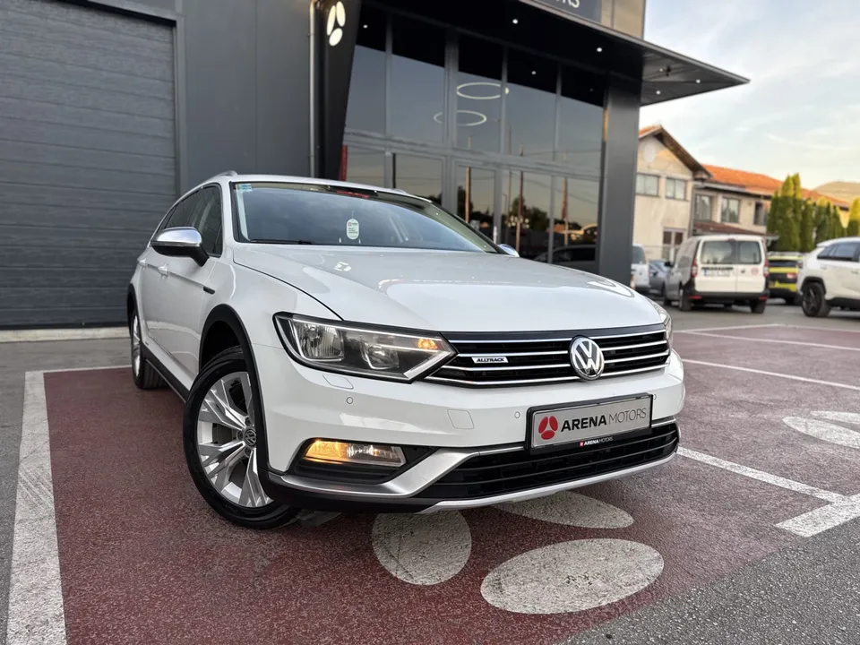 Bijeli Volkswagen Passat Alltrack, prednji desni ugao, ispred staklene fasade salona