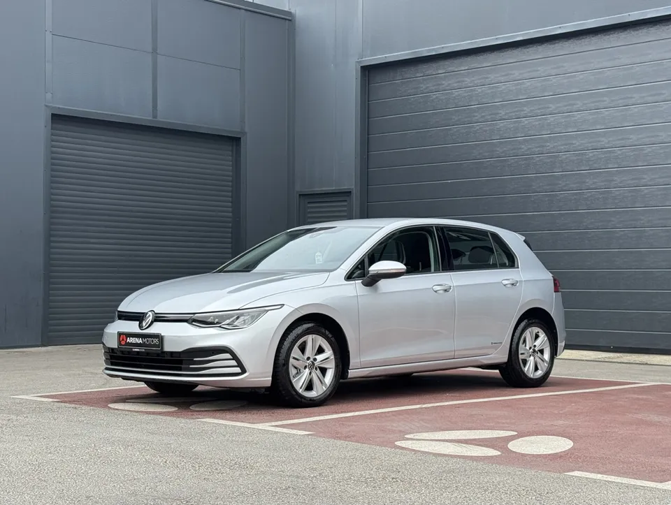 Sivi Volkswagen Golf 8, prednji bočni pogled s lijeve strane ispred tamne hale