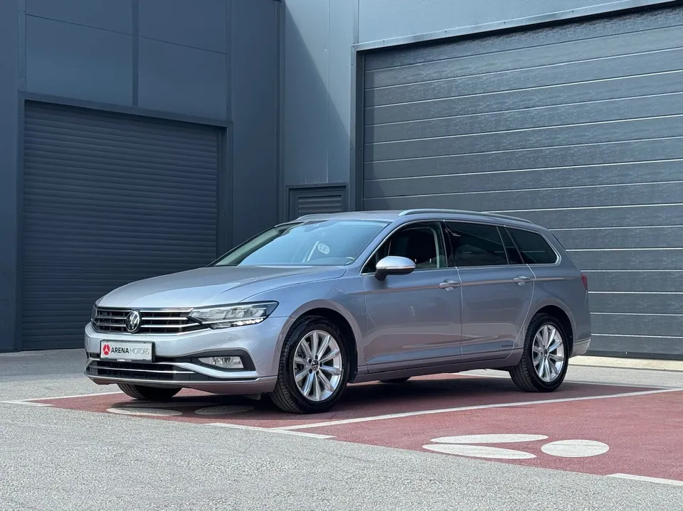 Volkswagen Passat karavan, siva boja, pogled sprijeda sa lijeve strane ispred sive garažne hale