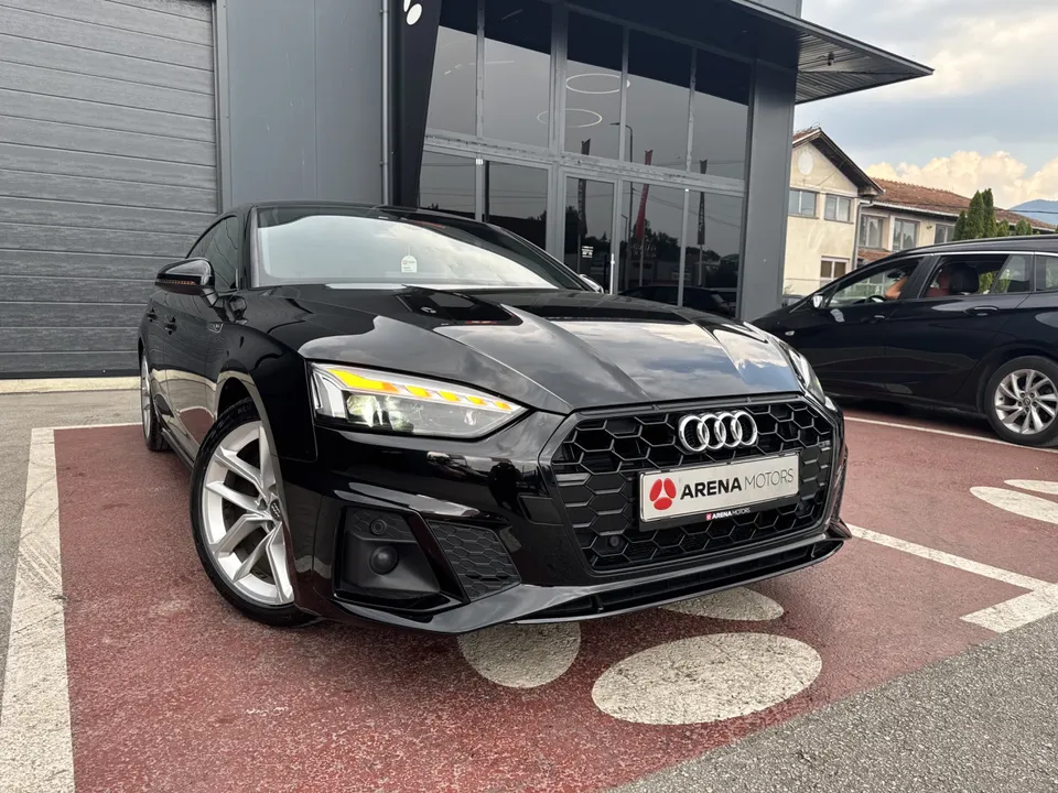 Crni Audi A5 Sportback, prednji desni ugao ispred staklene fasade salona