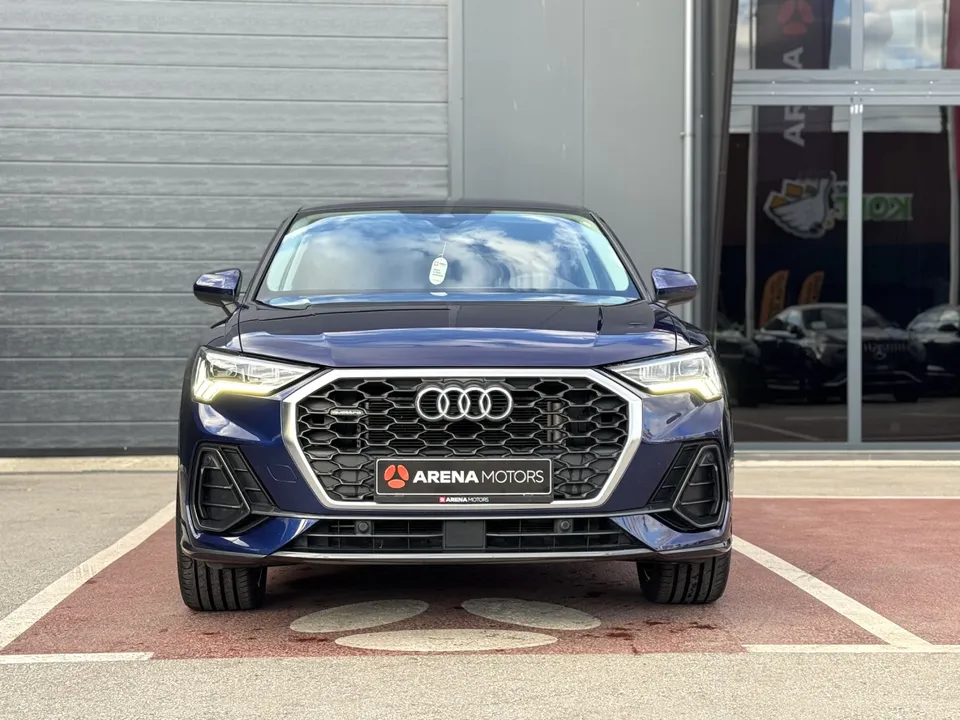 Audi Q3 Sportback plave boje, pogled sprijeda na rešetku s logom i LED farove