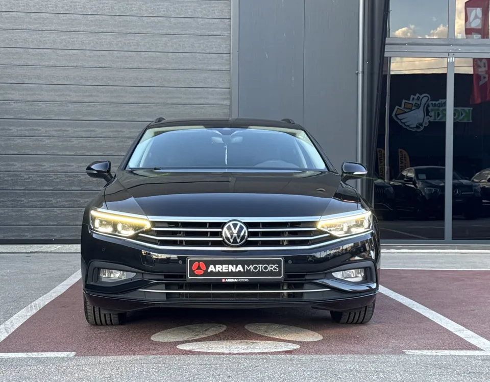 Crni Volkswagen Passat Variant, pogled spreda na masku, farove i branik na parkingu
