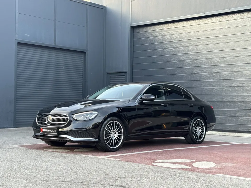 Crni Mercedes-Benz E 220 d, bočni pogled sprijeda s lijeve strane, 19" alu felge, ispred sive hale