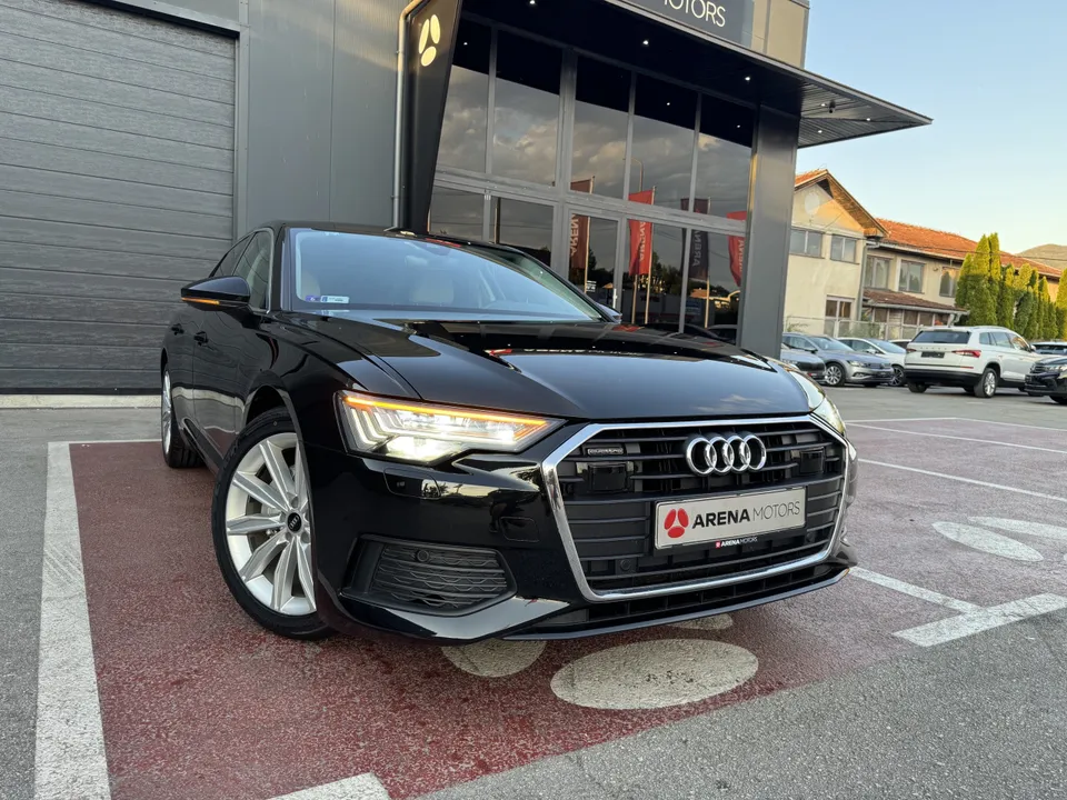 Audi A6 crne boje, prednji desni ugao ispred izloga salona