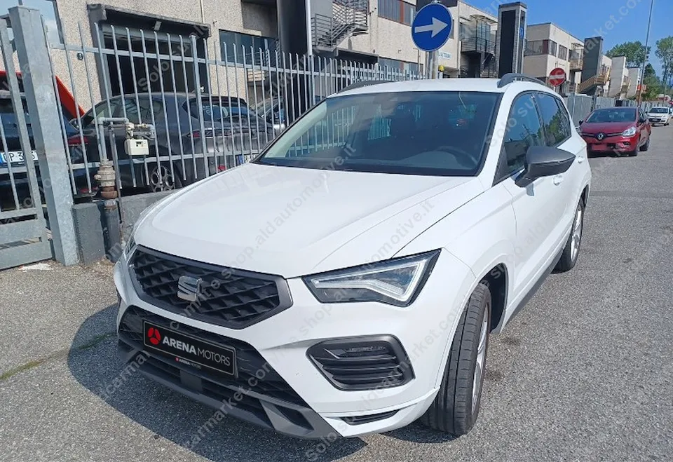 Bijeli Seat Ateca FR snimljen sprijeda i s lijeve strane na parkingu