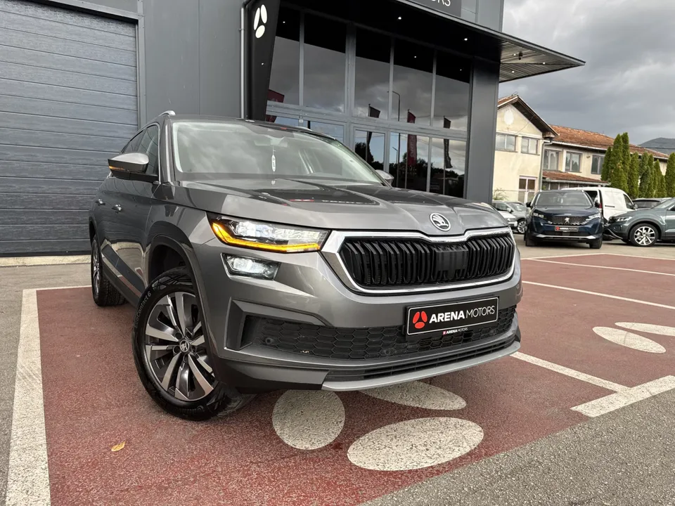 Škoda Kodiaq siva, prednji desni ugao ispred staklene fasade salona
