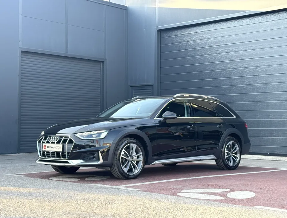 Audi A4 Allroad, crni karavan, prednji lijevi bočni pogled ispred sive hale