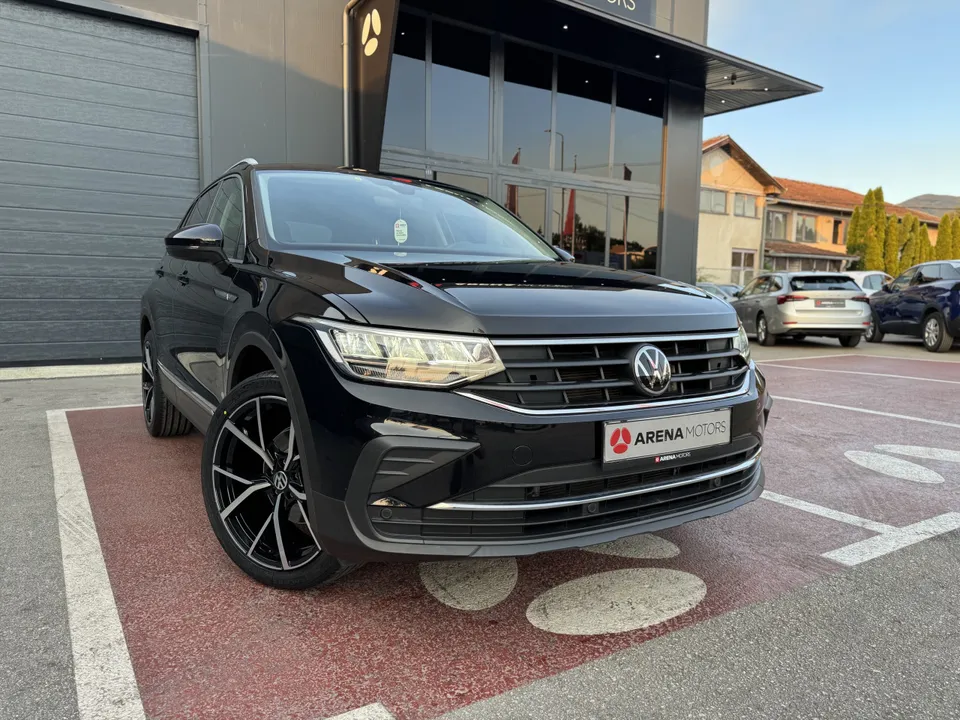 Crni Volkswagen Tiguan, prednji desni ugao ispred staklene fasade salona