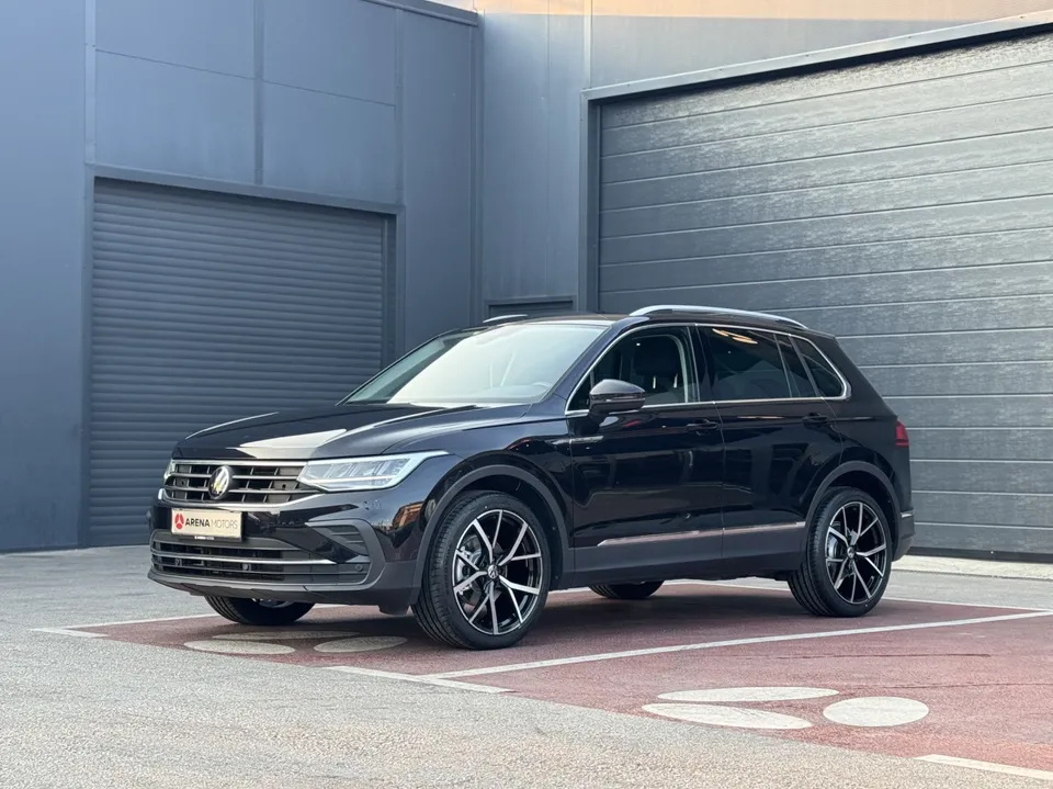 Crni Volkswagen Tiguan, prednji bočni pogled s lijeve strane ispred sivih garažnih vrata