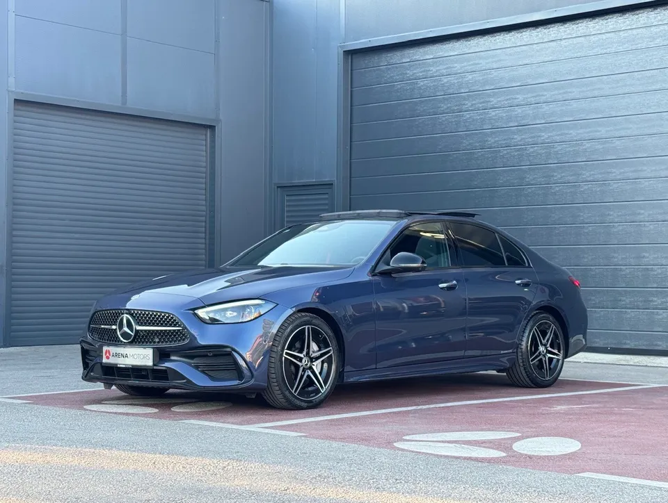 Plavi Mercedes-Benz C 220 d, prednji bočni pogled s lijeve strane ispred sivih vrata hale