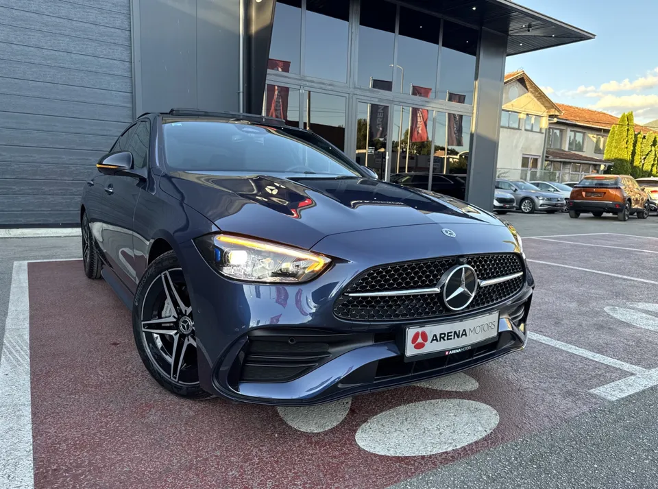 Prednji desni ugao plavog Mercedes-Benza C 220 d ispred staklene fasade salona
