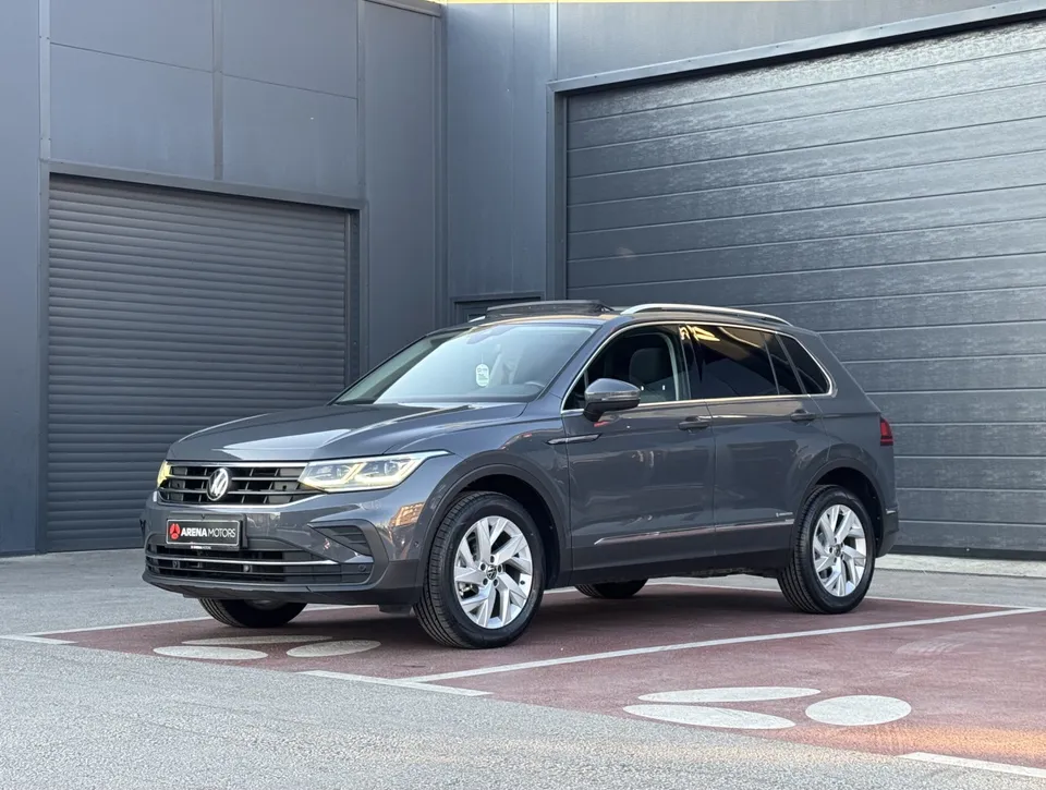 Volkswagen Tiguan u sivoj boji, prednji bočni ugao s lijeve strane, ispred tamne garaže