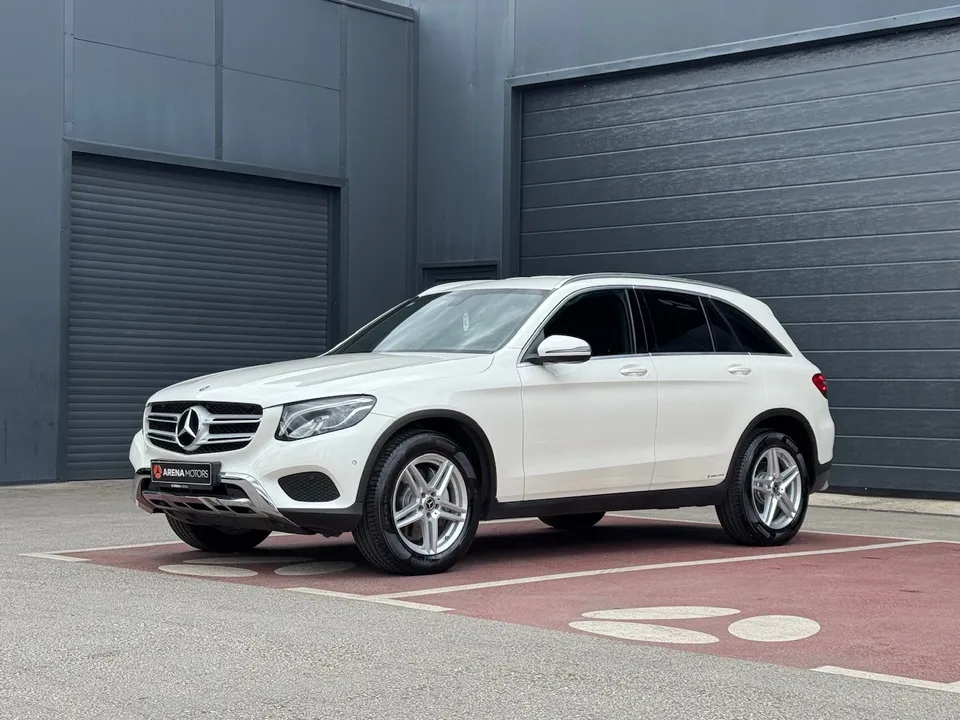 Bijeli Mercedes-Benz GLC 220 d, prednji lijevi bočni pogled, ispred tamne hale
