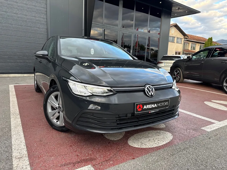 Volkswagen Golf 8, siv, prednji lijevi ugao ispred staklene fasade salona