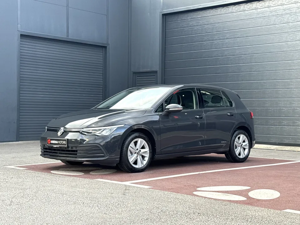 Volkswagen Golf 8, siv, prednji bočni ugao ispred sivih garažnih vrata
