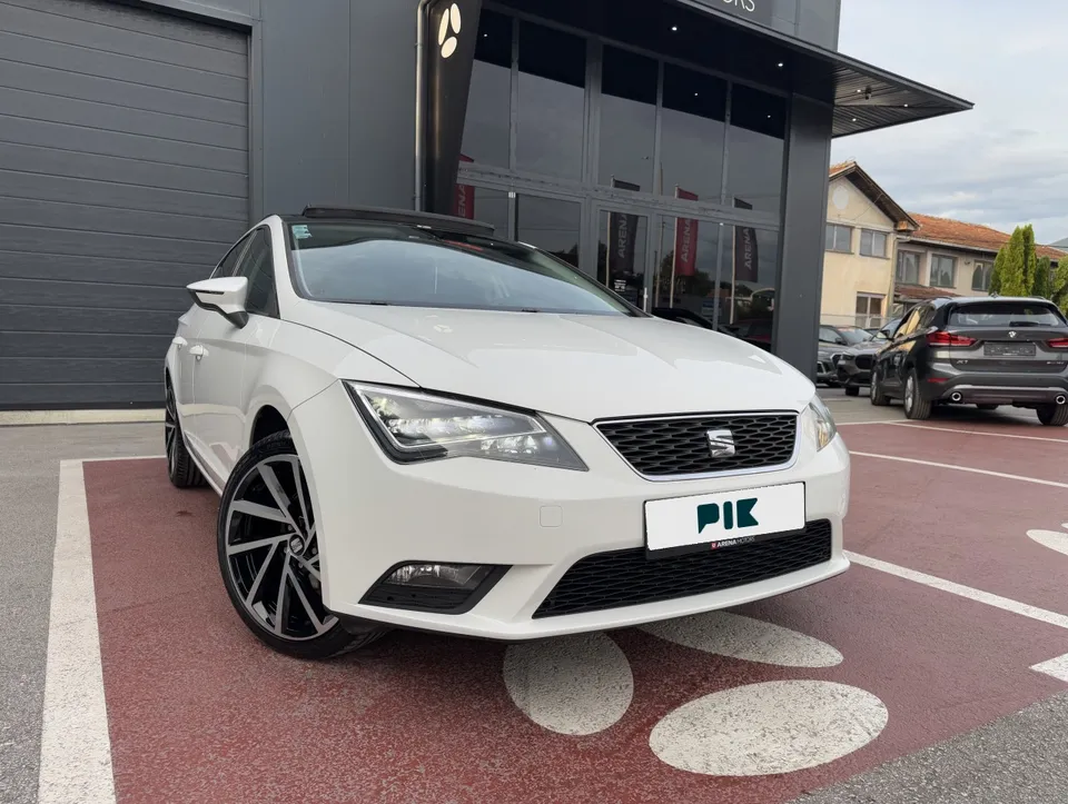 Bijeli Seat Leon, prednji desni ugao ispred salona Arena Motors