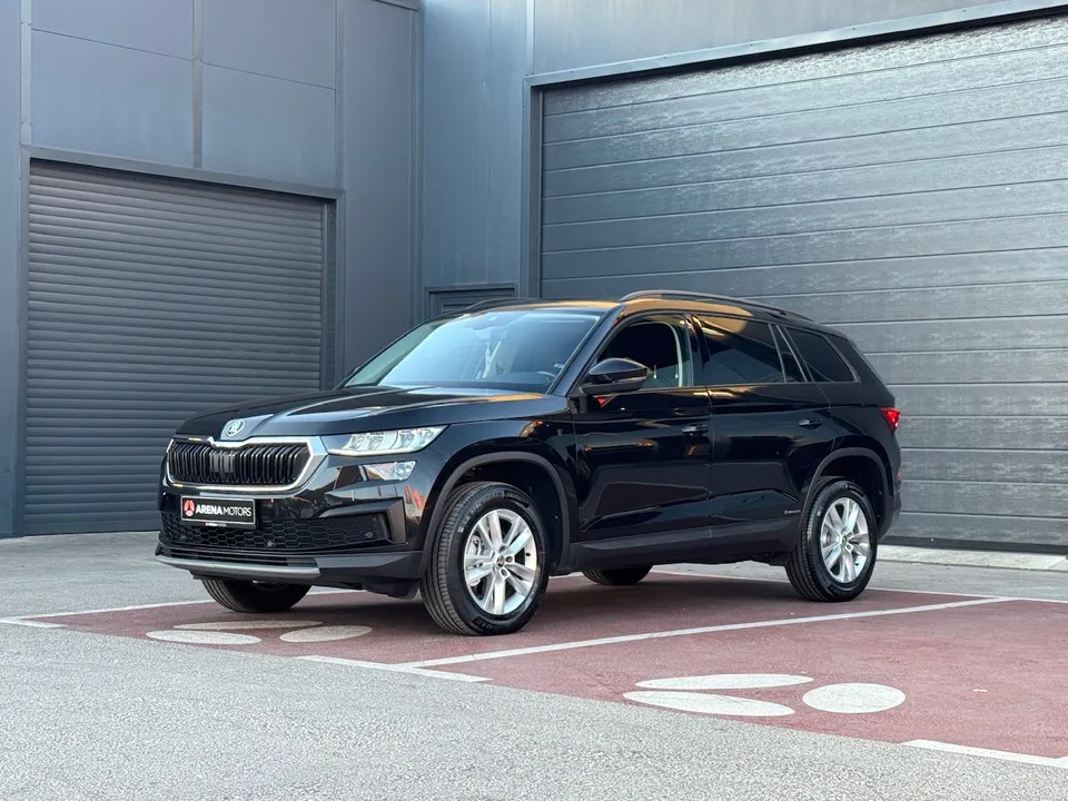 Crna Škoda Kodiaq, prednji bočni pogled sa lijeve strane ispred sive garaže