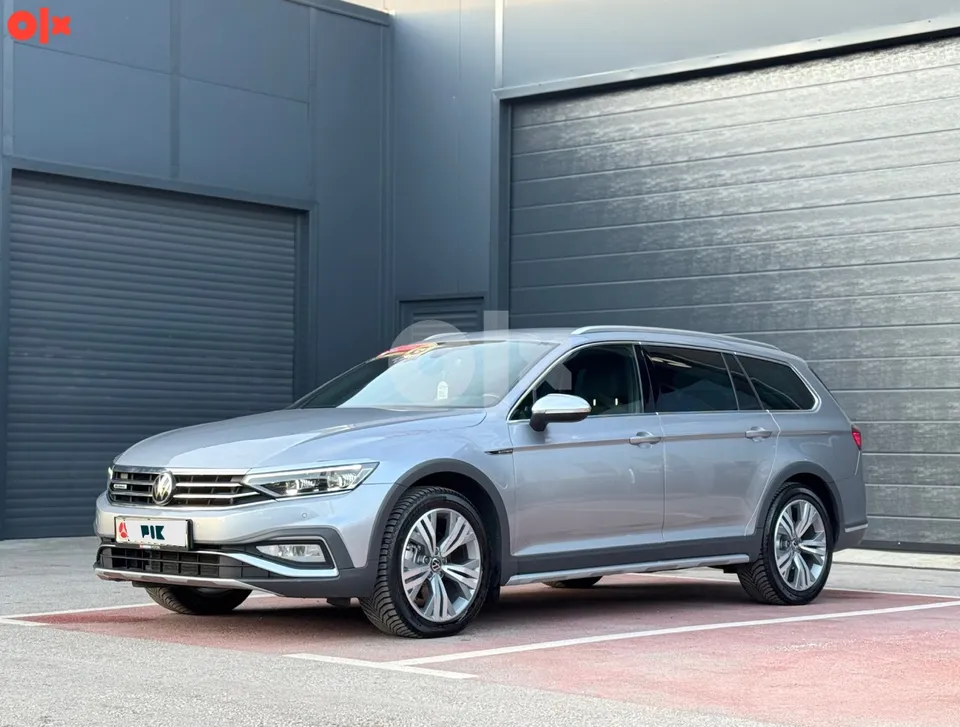 Volkswagen Passat Alltrack, siva boja, pogled sprijeda sa lijeve strane ispred tamnih garažnih vrata