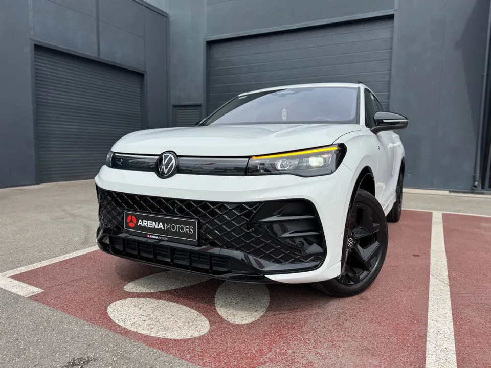 Volkswagen Tiguan bijele boje, prednji dio izbliza s LED svjetlima i crnom rešetkom, parking mjesto ispred salona